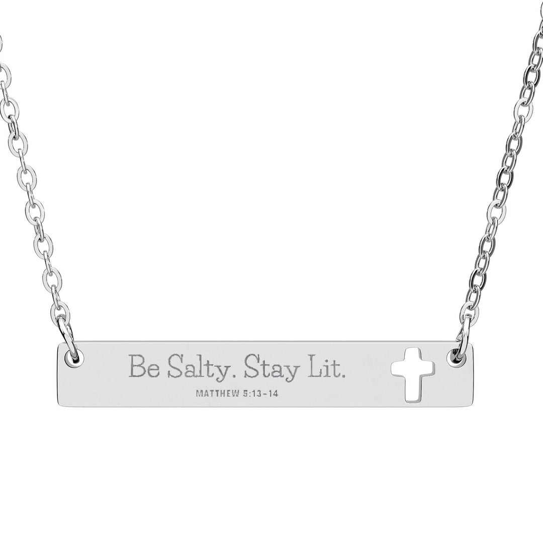 Silver necklace with bar pendant engraved 'Be Salty. Stay Lit.' and cross symbol.