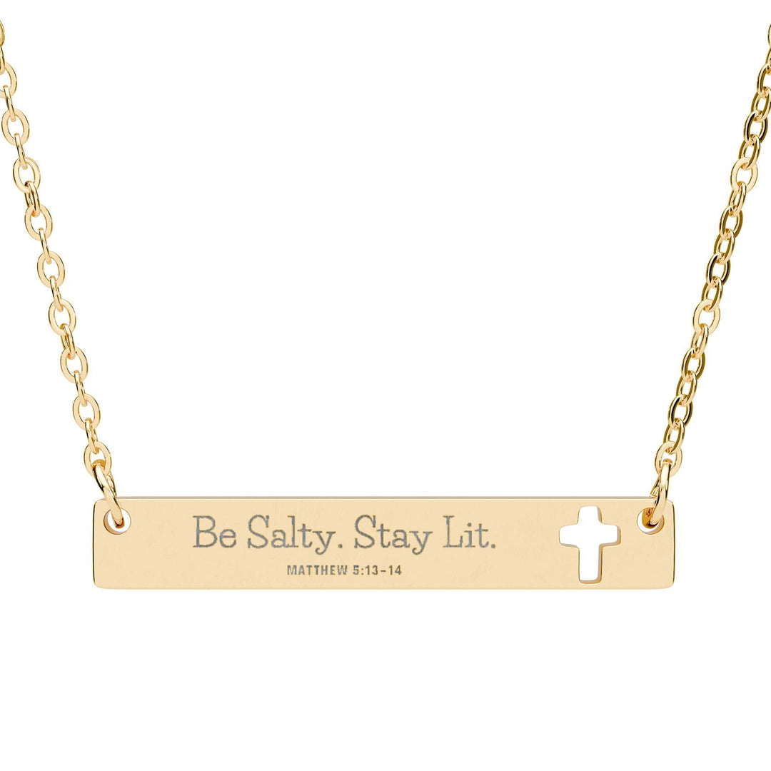 Gold necklace with bar pendant and cross, featuring 'Be Salty. Stay Lit.' text.