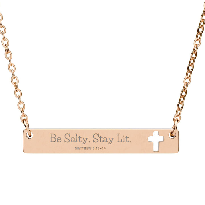 Rose gold necklace with bar pendant and cross, featuring 'Be Salty. Stay Lit.' text.